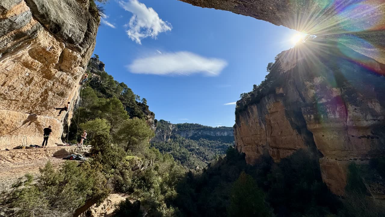 Vista del valle de Siurana desde un techo de roca, con escaladores preparando la vía